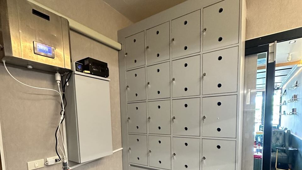 Private member lockers with individual keys, set against a dark wooden wall, at the Phuket cigar shop.